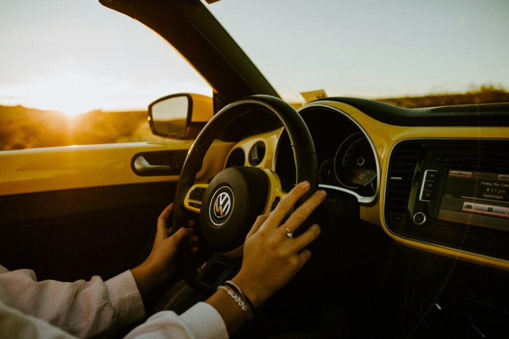 夕暮れの光の中でVWのハンドルを握る手