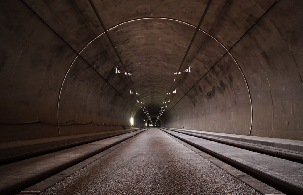 照明が灯る高速道路のトンネル内部を正面から見た写真