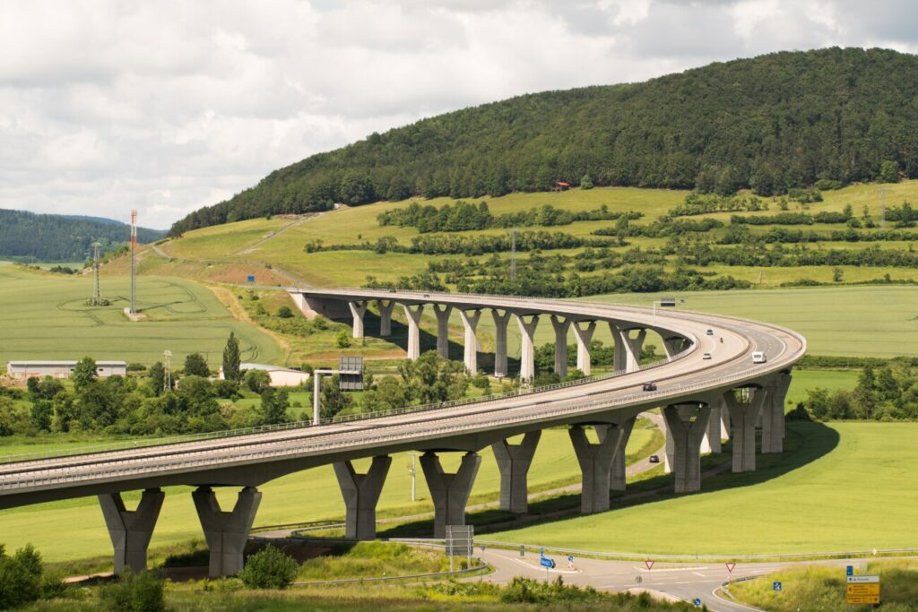 緑の丘と草原の中を走る高速道路の高架橋