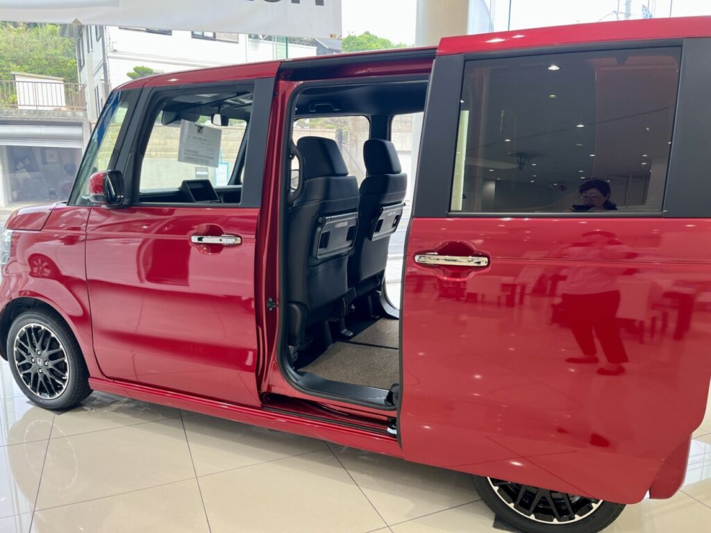 スライドドアを開けた赤い軽ハイトワゴンの側面。車体の大きさや乗り降りのしやすさを確かめる