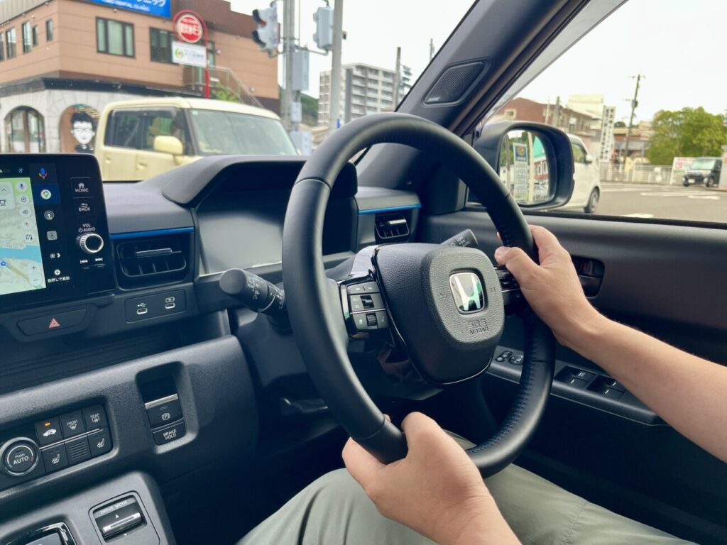 運転席からハンドルを握って市街地を走る様子。好きな車ほど運転する機会が自然と増えていく