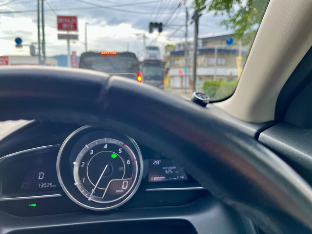 右ウインカーを出し、右折のタイミングを待つ車内のメーター