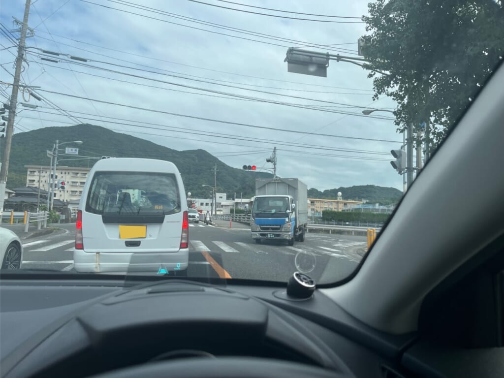 交差点で対向車を確認しながら右折待ちをする車