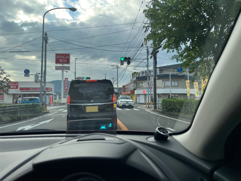 青信号の交差点で前方の対向車を確認する車内
